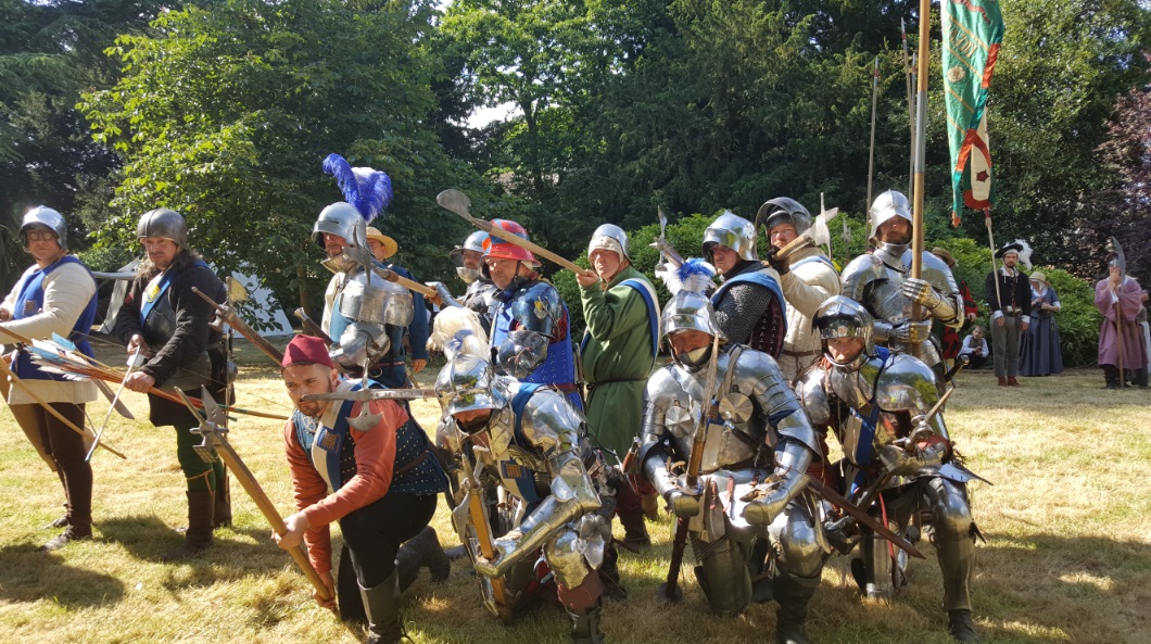 Beaufort Companye in full medieval armour with their weapons pointed towards the camera