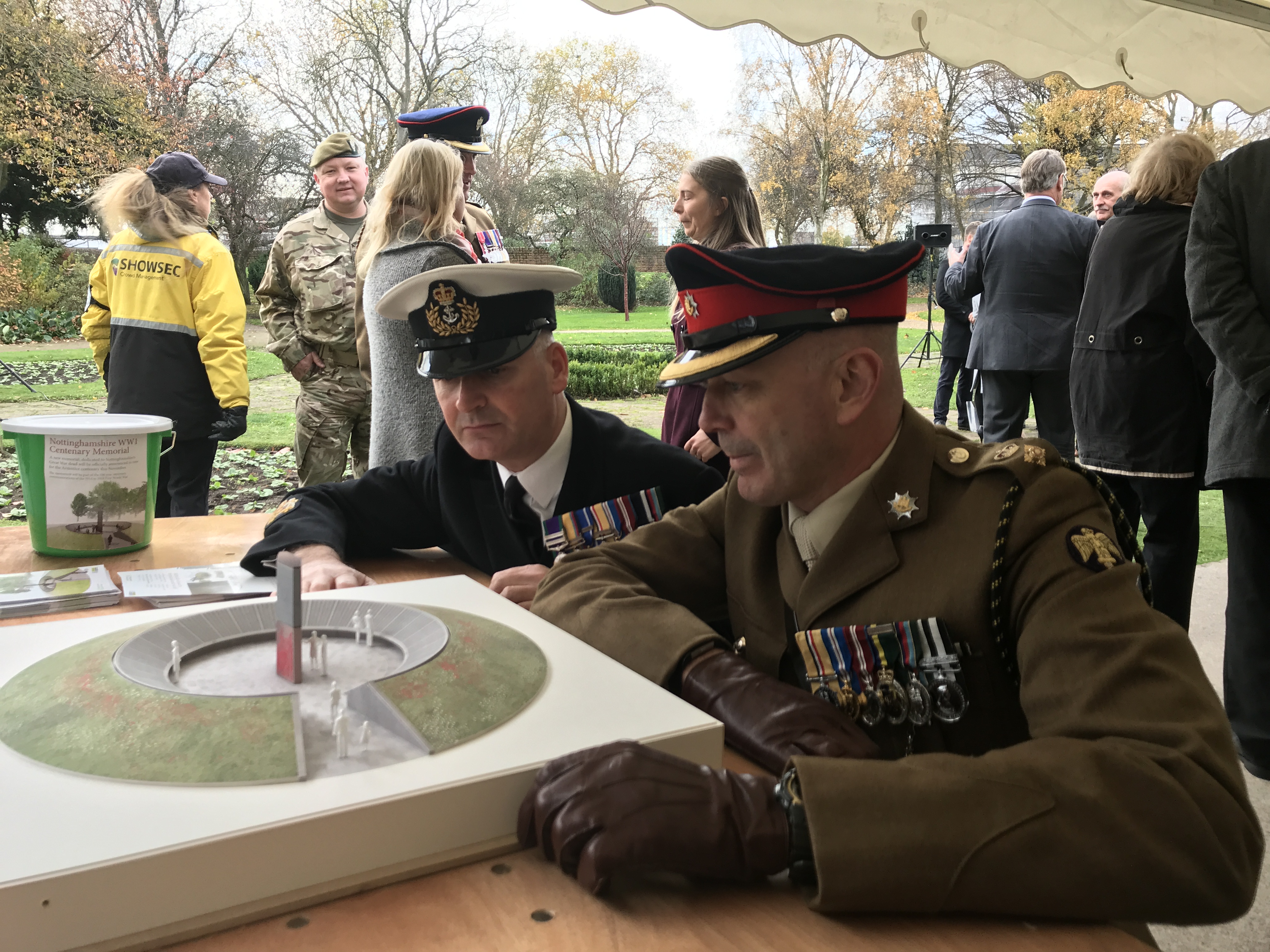 Two uniformed officers look at a model of the new memorial