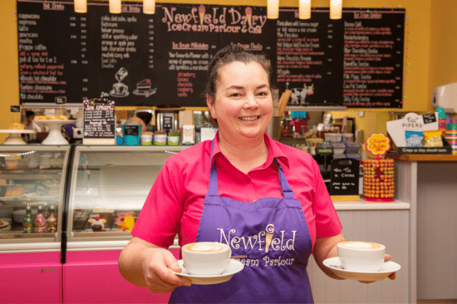 Member of staff serving coffee at Newfield Dairy Ice Cream Parlour
