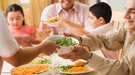 Family passing food to each other at a dinner table