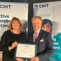 Left to right - Bikeability's Tracy Graham and Cllr Neil Clarke holding the CIHT award at the event in front of two CIHT pull up banners
