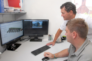Steff Wright chats to architect Ricky Maynard (seated) about their latest project. Large files can easily be sent to clients using their new high speed broadband connection