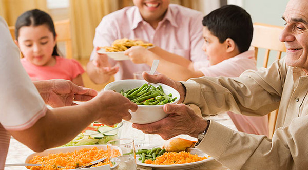 Family passing food to each other at a dinner table