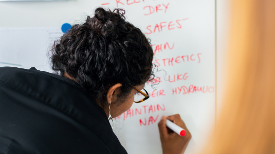 Person writing on a white board