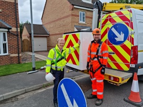 Cllr Clarke and a Via operative standing in front of a van and a lampost after installing the last LED light