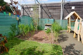Outdoor garden and nature area with a small grassy lawn.