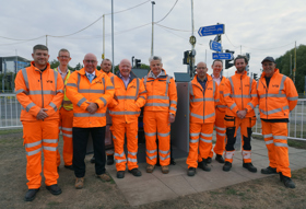 Team dressed in orange Hi-Vis safety gear. Image shows: (L-R) Jake Mason – Contract agent, Via East Midlands Rob Dean - Senior Electrical design manager , Via East Midlands Cllr Mick Barton - Leader of the county council Dan Maher - Managing director Via East Midlands Cllr Bert Bingham - Cabinet member for transport and environment Christopher Read - Electrical chargehand, Via East Midlands Chris Gough - Head of highway infrastructure services And other members of the project team.