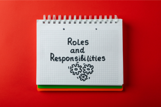 Writing pad with the words roles and responsibilities and drawings of cogs on the page